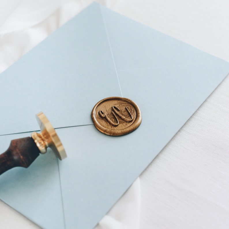 custom wax seal stamp on blue envelope with wooden handle stamp tool